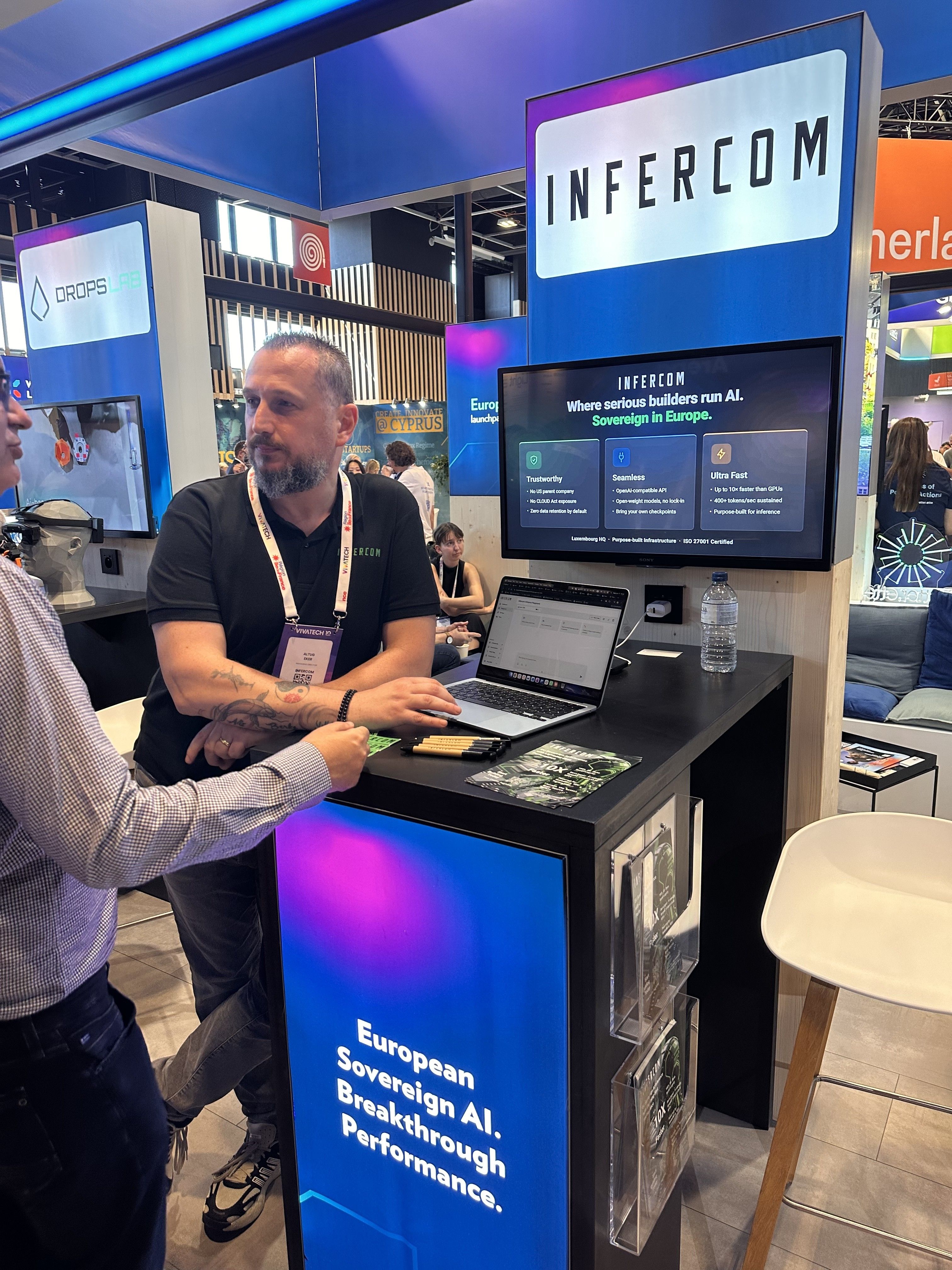 Altug Eker di Infercom ascolta un visitatore allo stand di Infercom a VivaTech Parigi